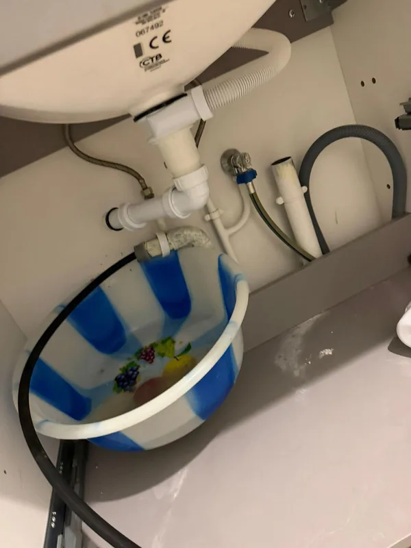 Fuite sous évier avec siphon et bassine de récupération